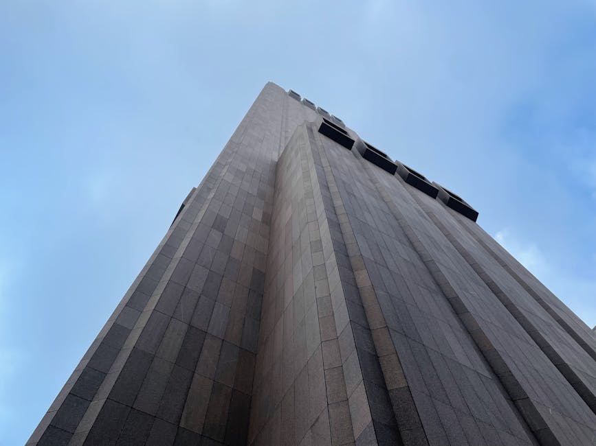 Low angle view of a modern skyscraper in New York City against a clear blue sky